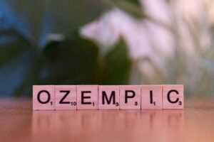 Scrabble tiles spelling 'Ozempic' on a wooden surface, healthcare theme.