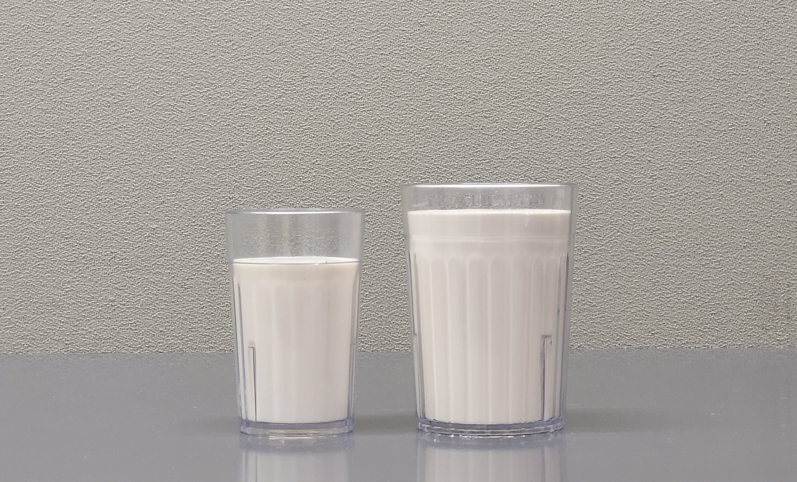Two glasses of milk on a table