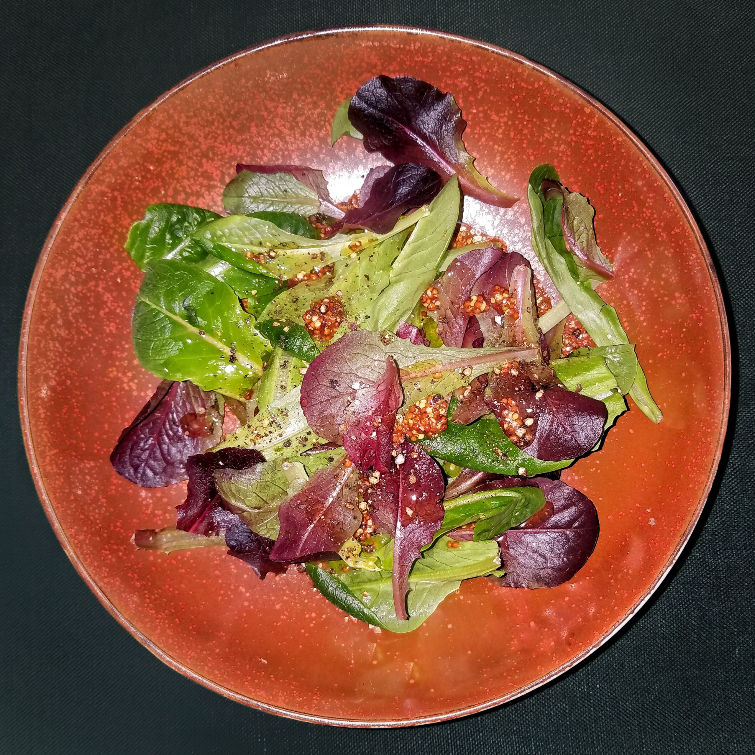 Mixed green salad with olive oil, vinegar, and mustard dressing