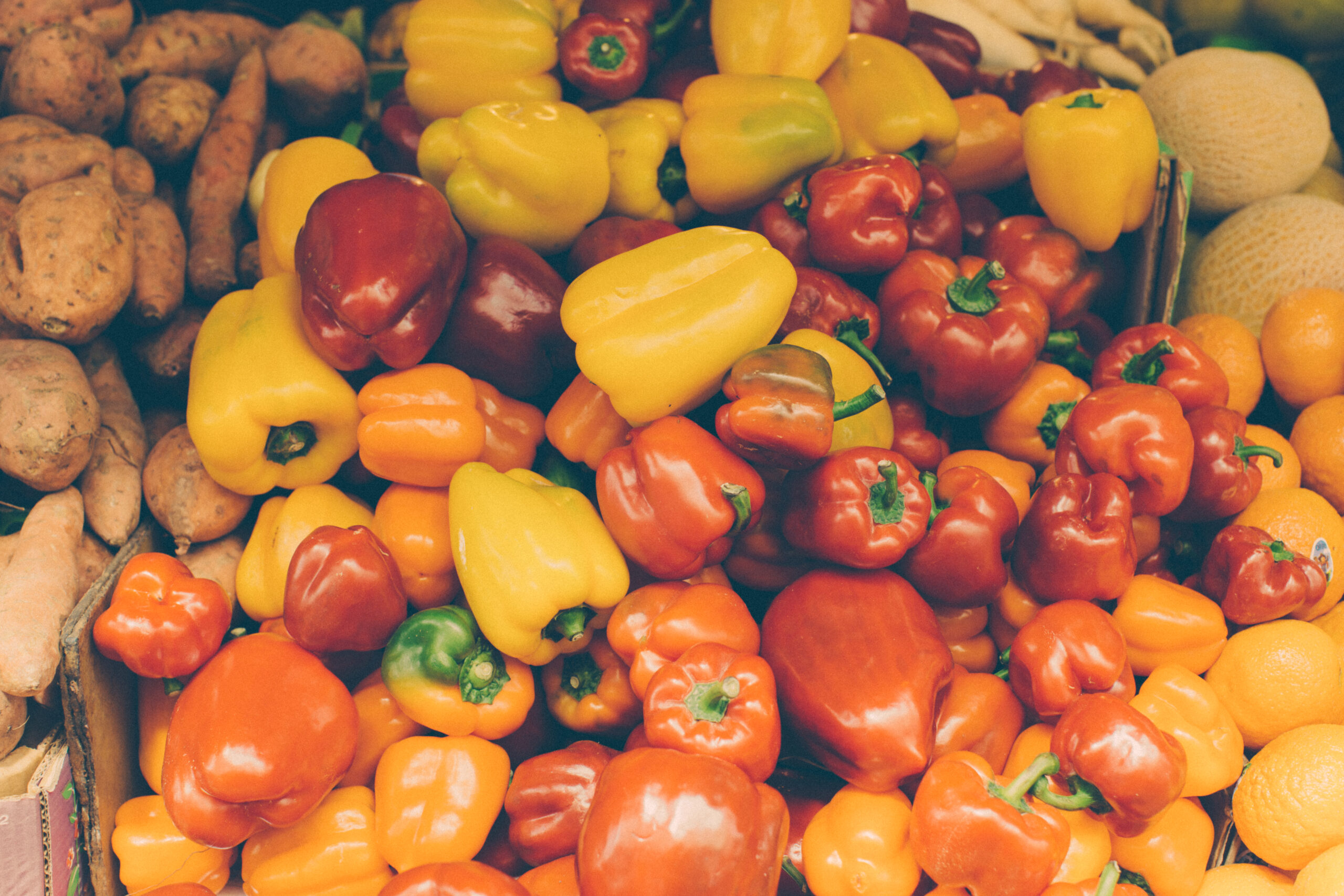 Colourful red orange and yellow bell peppers at a market