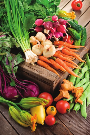 A pile of mixed vegetables including peppers, broccoli, carrots, and other produce