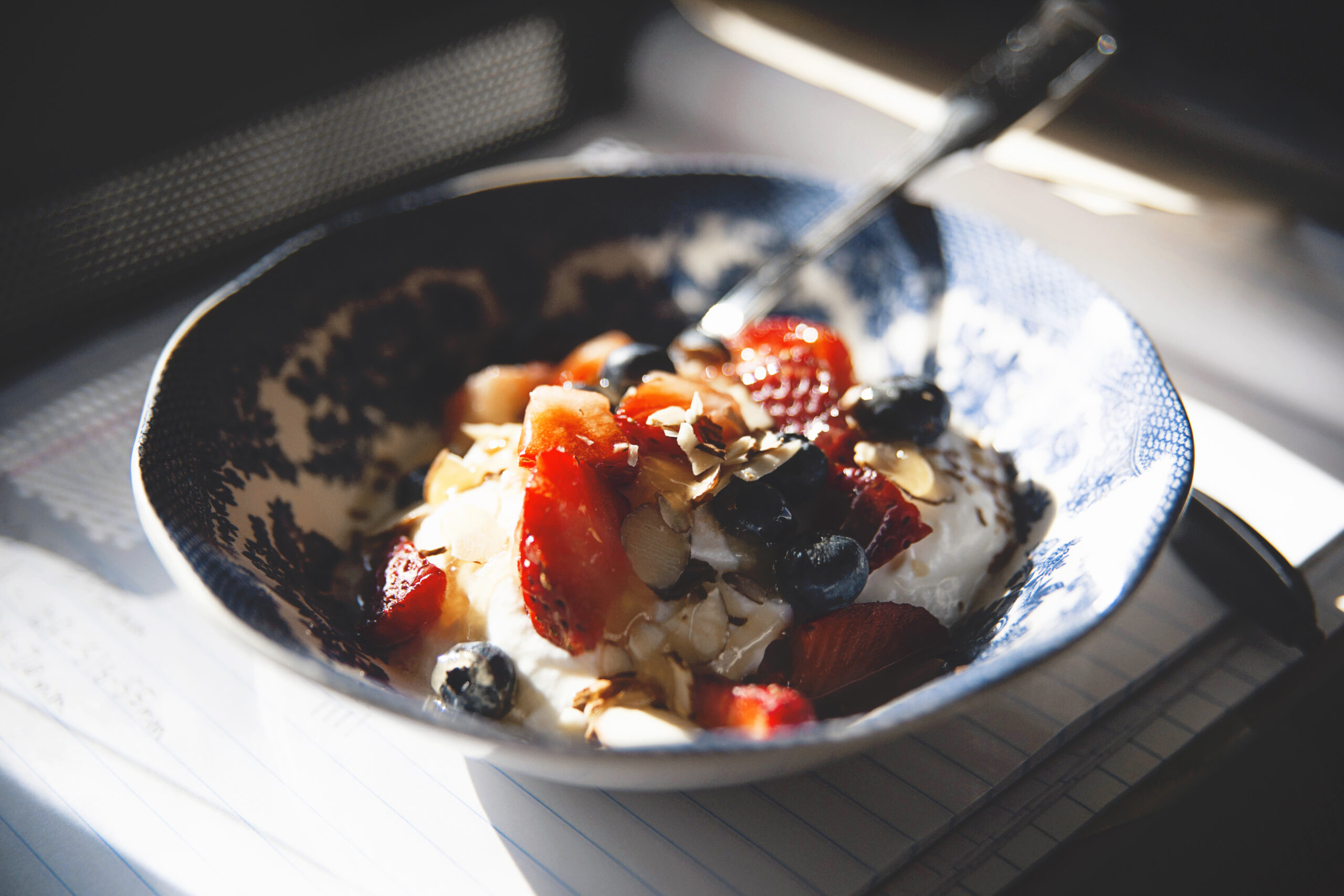 A bowl of fruit and yoghurt topped with nuts for a healthy breakfast